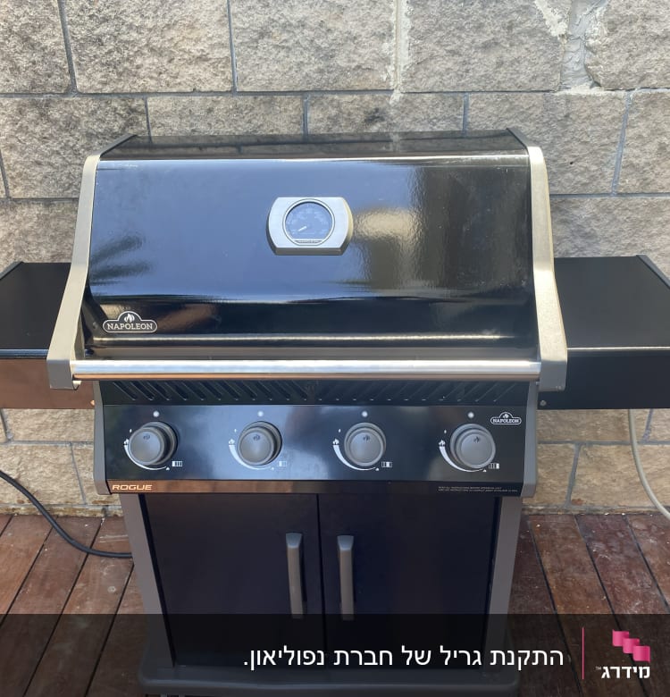 גריל גז שחור עם שלושה כפתורים ומד חום